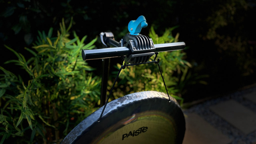 A close-up of a bicycle stand suspending a Paiste Gong which is held by The Bong Bar.