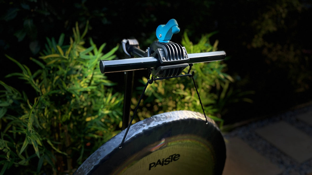 A close-up of a bicycle stand suspending a Paiste Gong which is held by The Bong Bar.