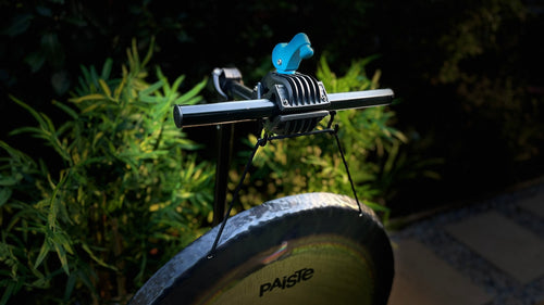 A close-up of a bicycle stand suspending a Paiste Gong which is held by The Bong Bar.